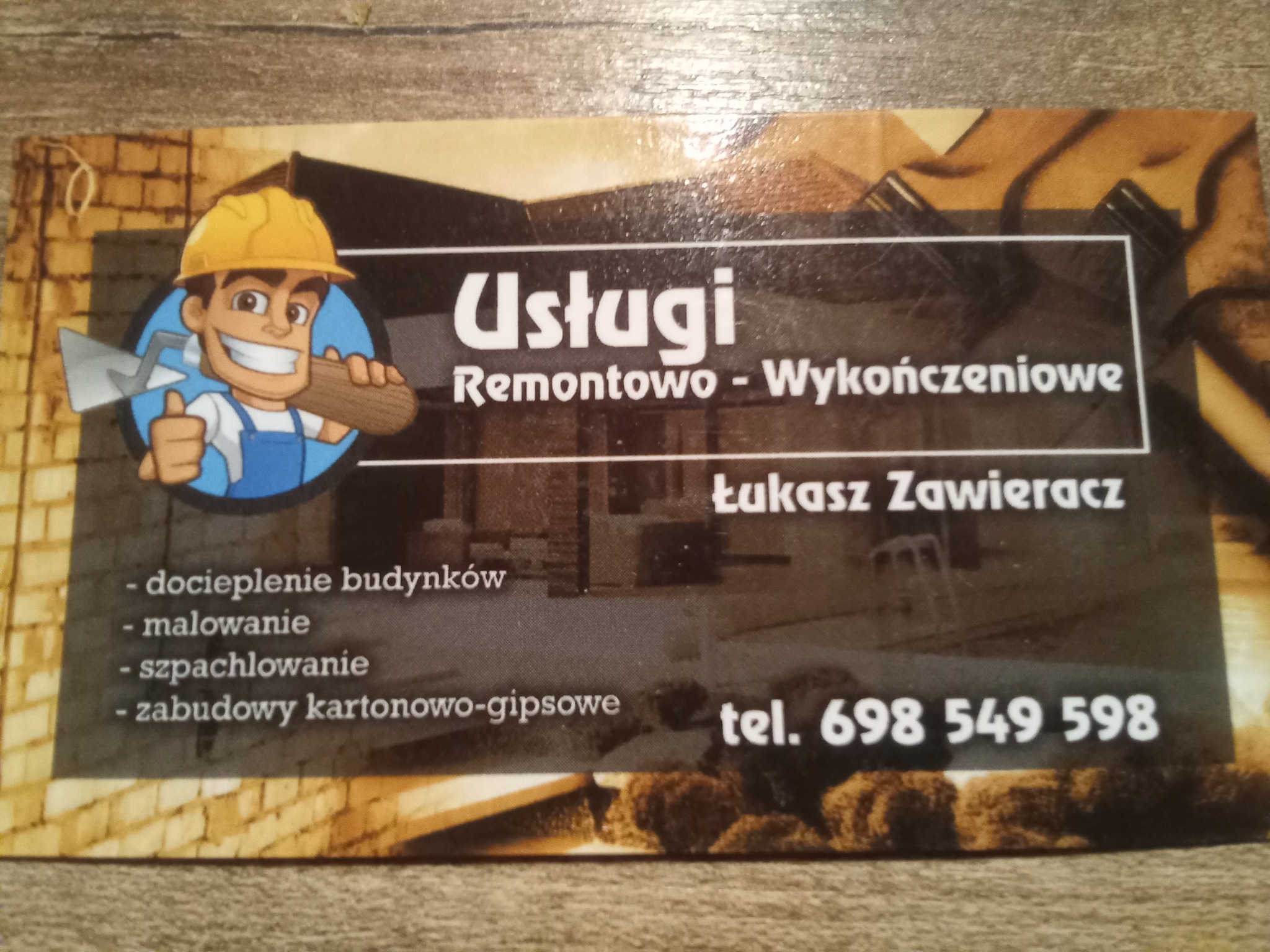 Wizytówka firmy remontowo-wykończeniowej z uśmiechniętym, animowanym budowlańcem w kasku trzymającym kielnię, oferującej docieplenie budynków, malowanie, szpachlowanie i zabudowy kartonowo-gipsowe,...