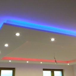 Usług remotowo-wykończeniowe MAG - Podwieszany sufit z oświetleniem LED w kolorach niebieskim i czerwonym oraz halogenami, widoczne okna w tle.