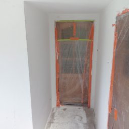 Sławomir kak - Przygotowanie do malowania: zabezpieczone folią drzwi i ściany wnęki, widoczne ślady farby na podłodze.