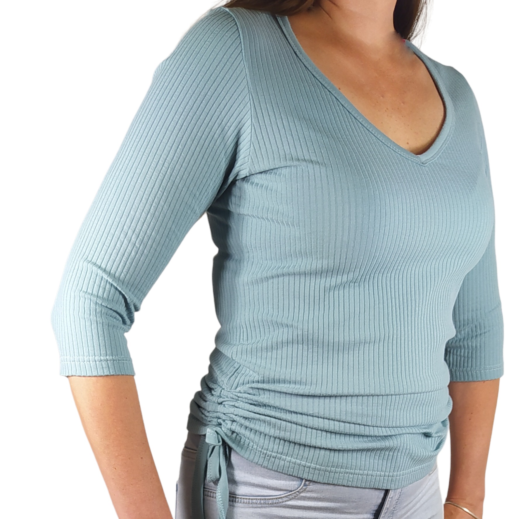 Kobieta prezentuje bluzkę w prążki z dekoltem w serek i rękawami 3/4, z marszczeniem po bokach regulowanym sznurkiem.