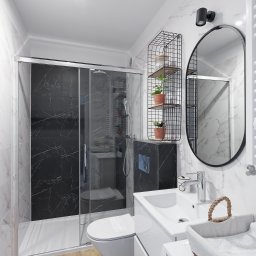 Sprawdzone Remonty - Nowoczesna łazienka z kabiną prysznicową typu walk-in z czarnymi płytkami imitującymi marmur, wiszącą toaletą, umywalką z szafką, owalnym lustrem w czarnej ramie i drewnopodobną podłogą, oświetlona...