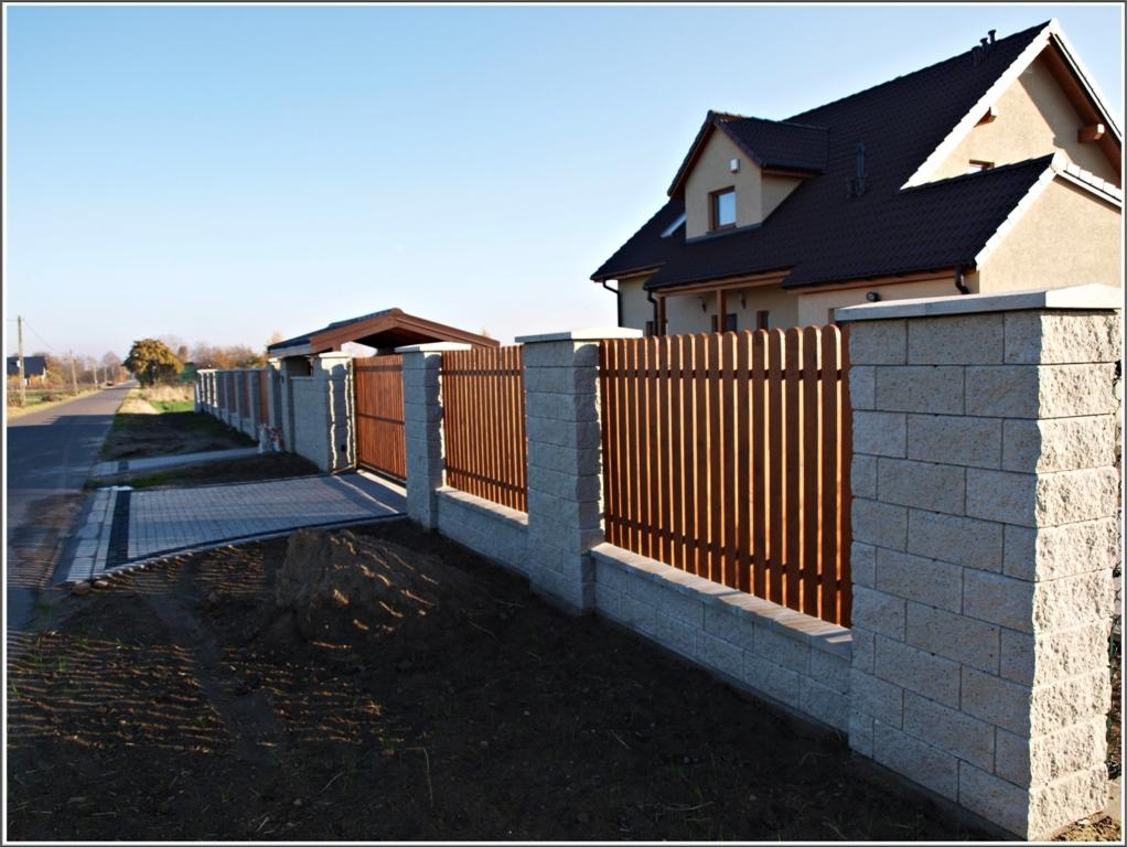 Nowoczesne ogrodzenie panelowe z bloczków betonowych i drewnianych przęseł w Zgierzu, z bramą wjazdową i kostką brukową, na tle domu jednorodzinnego.
