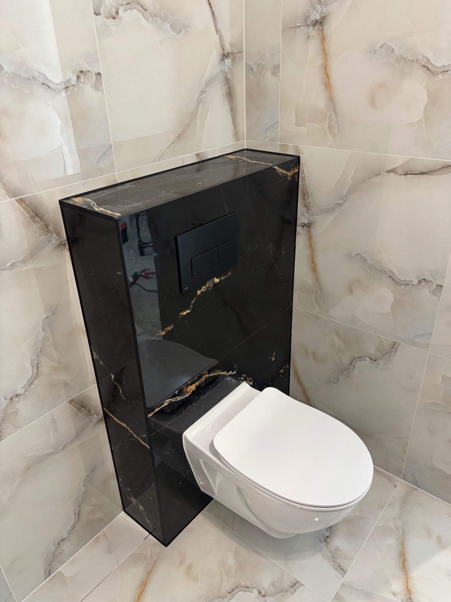 Elegancka toaleta podwieszana z czarną obudową i marmurowymi płytkami w Olsztynie. Nowoczesny design, wysoki połysk, precyzyjne wykończenie.