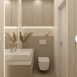 Nowoczesna łazienka w beżowej tonacji z podwójną umywalką nablatową, minimalistyczną toaletą podwieszaną i dekoracyjnymi suszonymi trawami w wazonie.