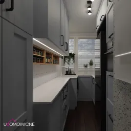 Wąska kuchnia w szarościach z drewnianymi akcentami: półka na przyprawy, drewniana podłoga i czarne uchwyty szafek.