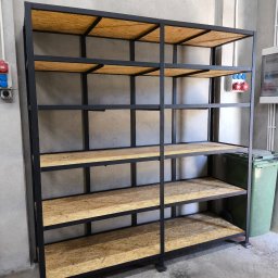 RAF-SPAW RAFAŁ KOPCZYK - Metalowy regał z półkami z płyty OSB, spawana konstrukcja w surowym wnętrzu warsztatu.