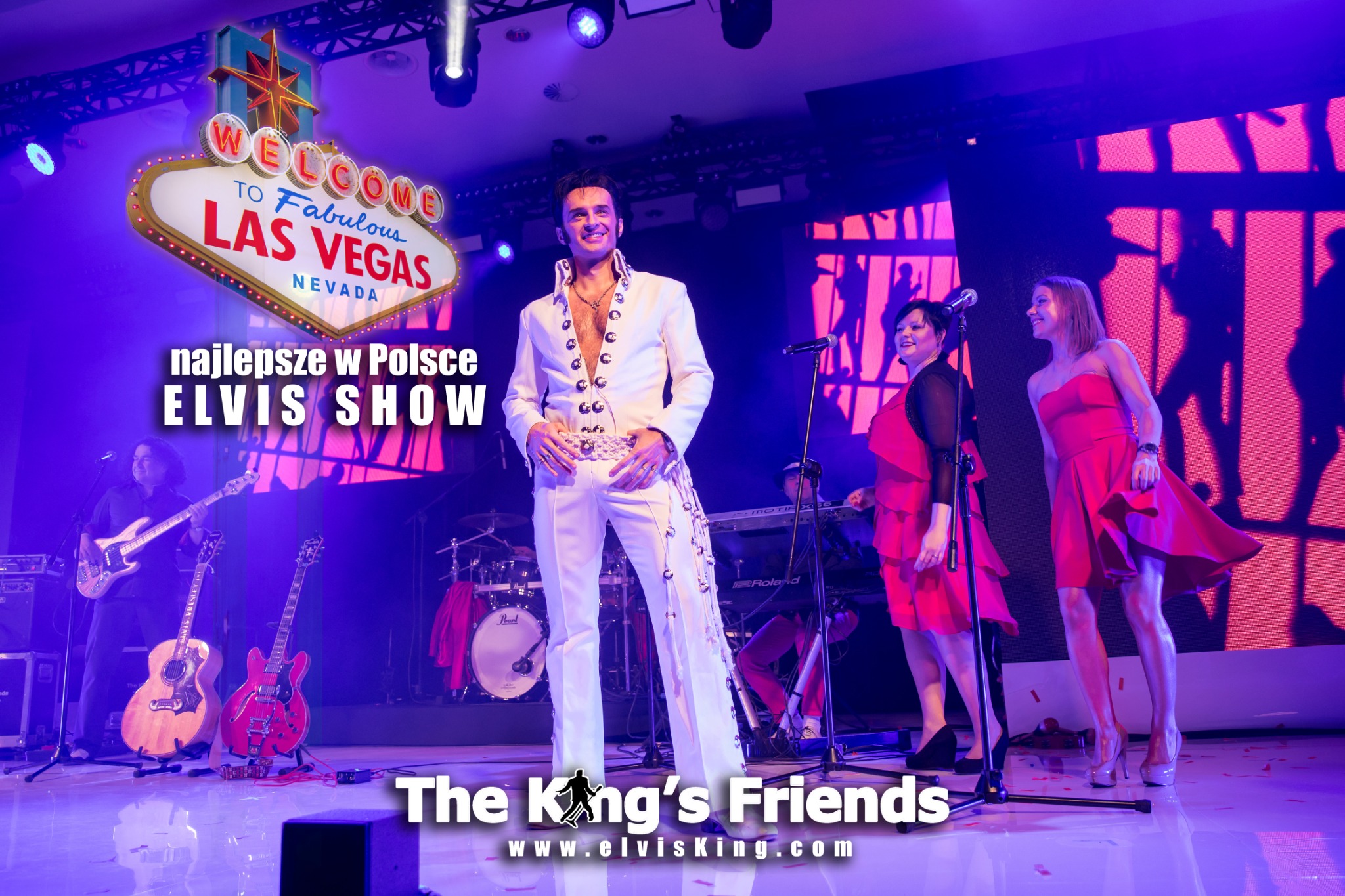 Elvis Presley tribute artist in a white jumpsuit performing on stage with a band and dancers, Las Vegas sign backdrop, stage lighting, and logo 'The King's Friends'.