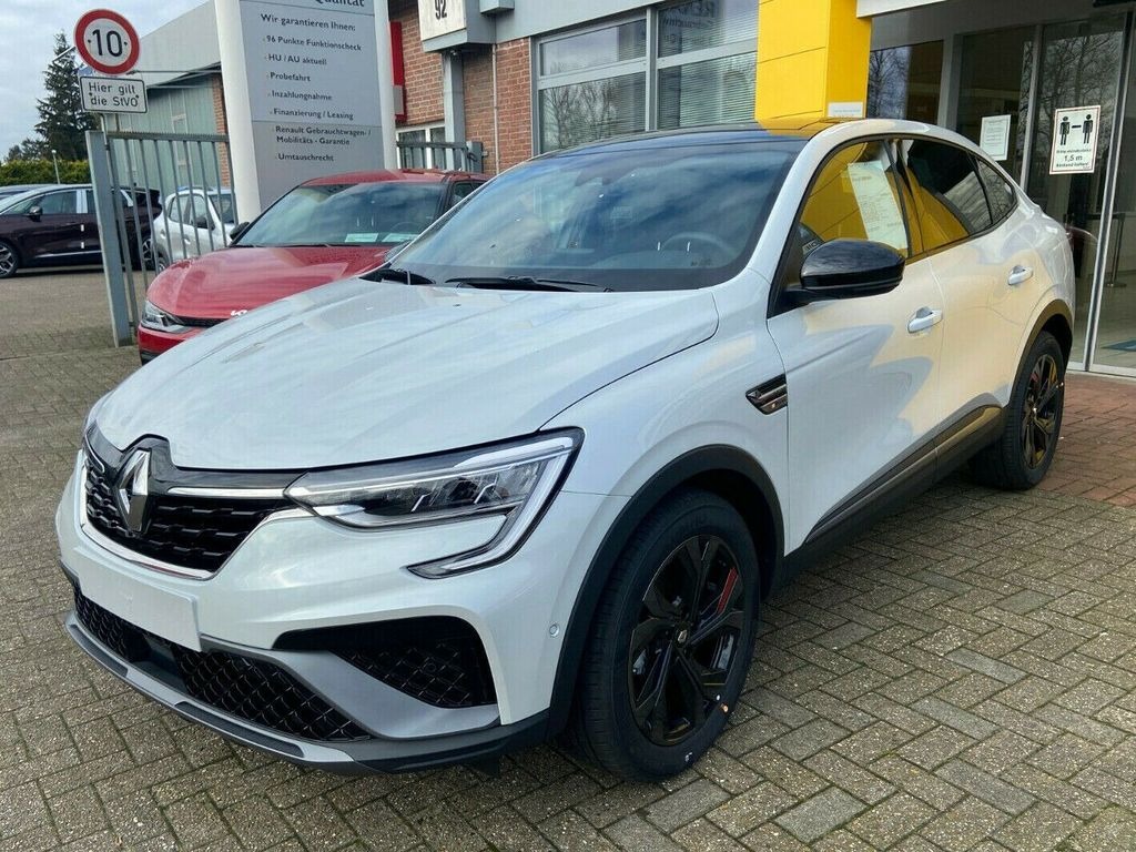 Biały samochód Renault Arkana na tle salonu samochodowego z widocznymi znakami informacyjnymi i innymi pojazdami.