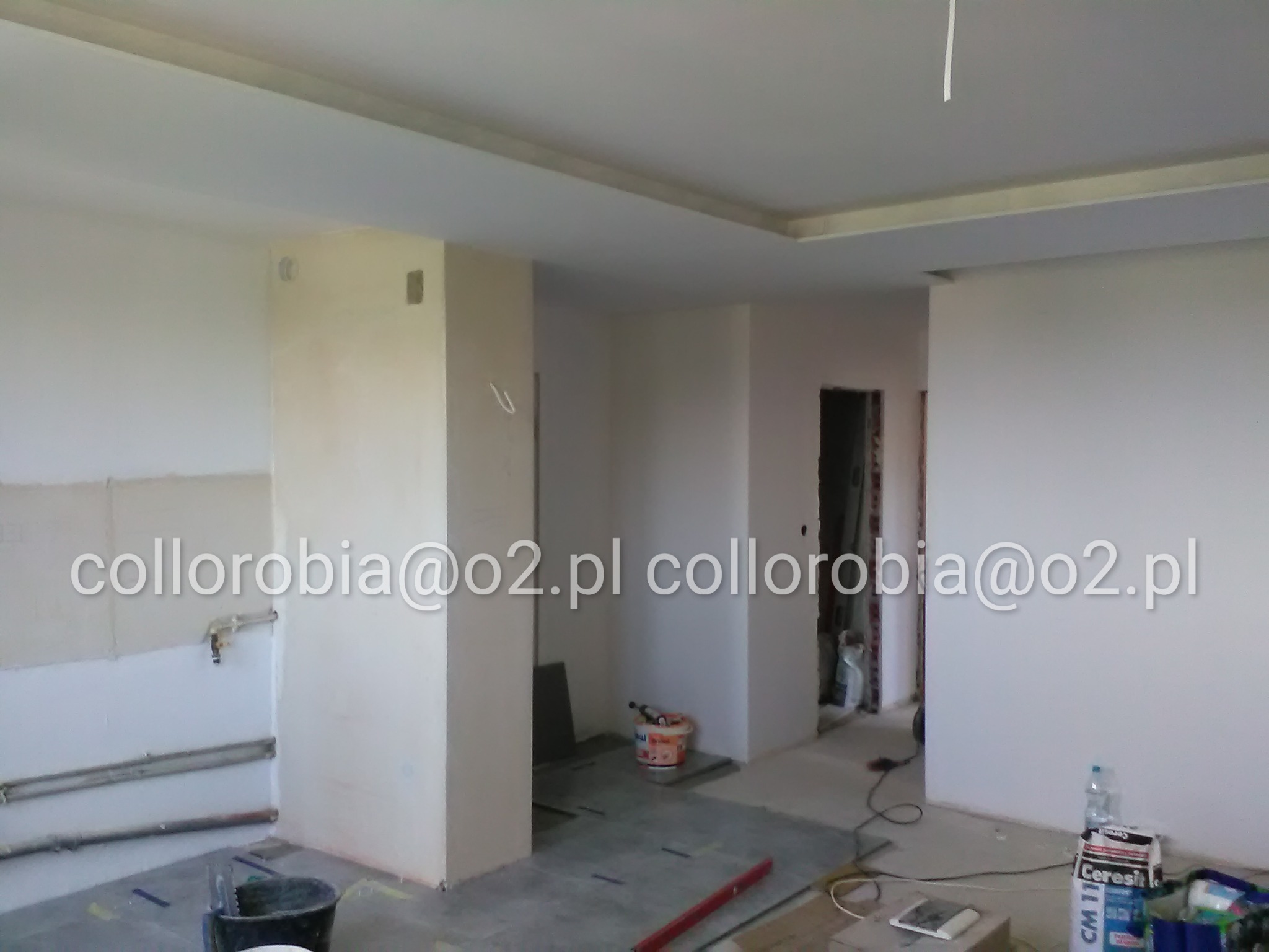 Wnętrze w trakcie prac wykończeniowych: widoczne tynki, gładzie, zabudowy z płyt gipsowo-kartonowych, przygotowane do dalszych prac, na podłodze narzędzia i materiały budowlane, widoczny kubeł...