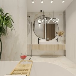 COLIBRIART PRACOWNIA WNĘTRZ EWA ŚWIDERSKA-BASIAK - Nowoczesna łazienka z okrągłym lustrem, designerską lampą i roślinami. Wanna z drewnianą półką i kieliszkiem wina. Eleganckie wykończenie w jasnych barwach.
