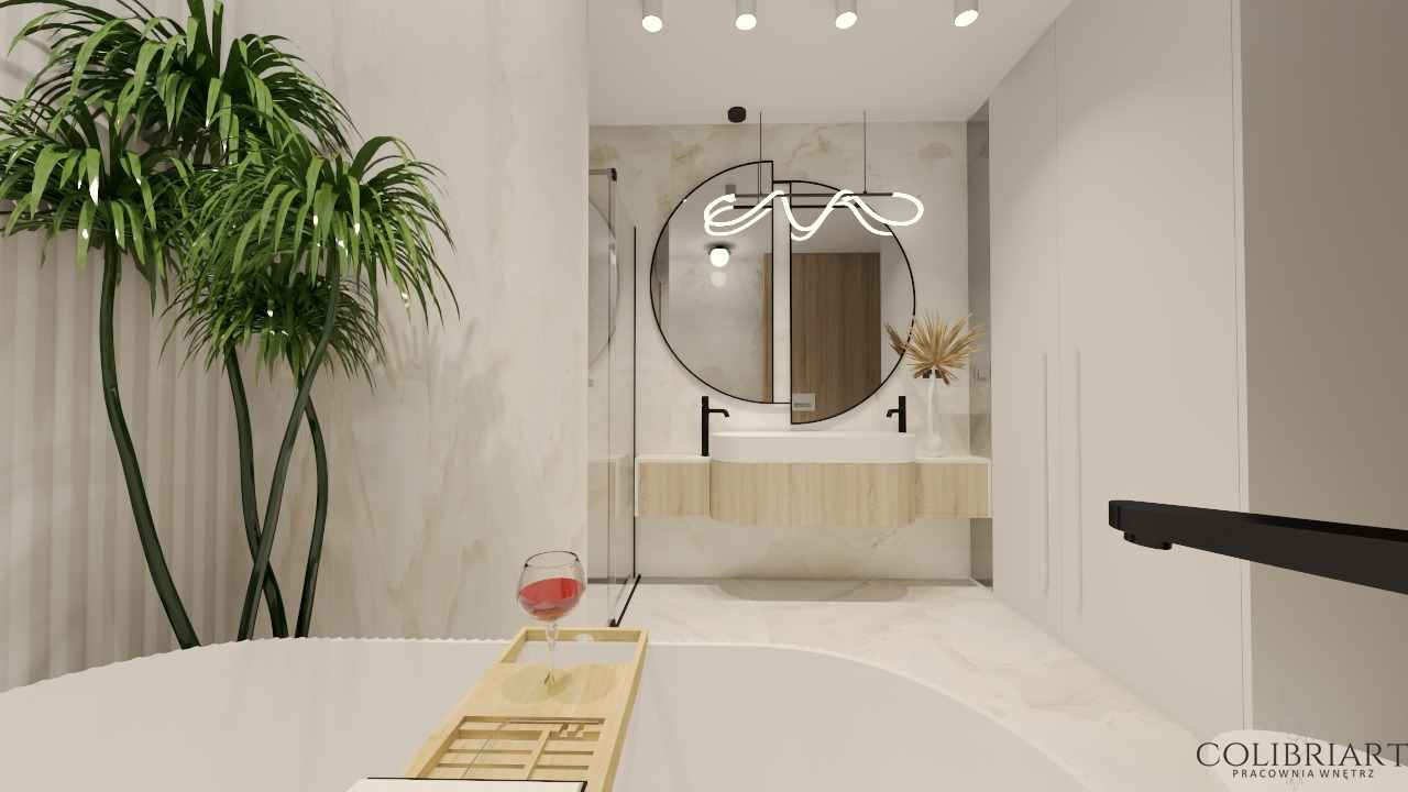 Nowoczesna łazienka z okrągłym lustrem, designerską lampą i roślinami. Wanna z drewnianą półką i kieliszkiem wina. Eleganckie wykończenie w jasnych barwach.