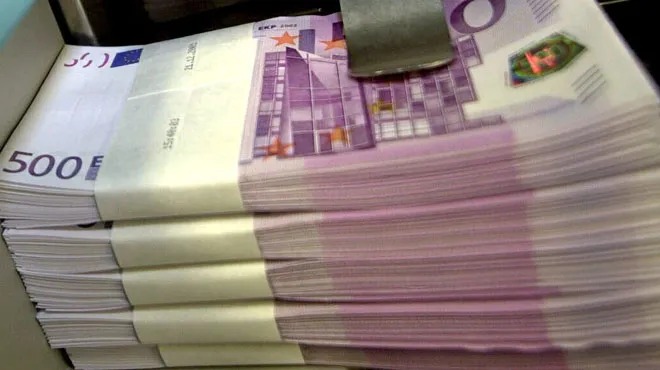 Stosy banknotów 500 euro, zabezpieczone banderolami, ułożone jeden na drugim.