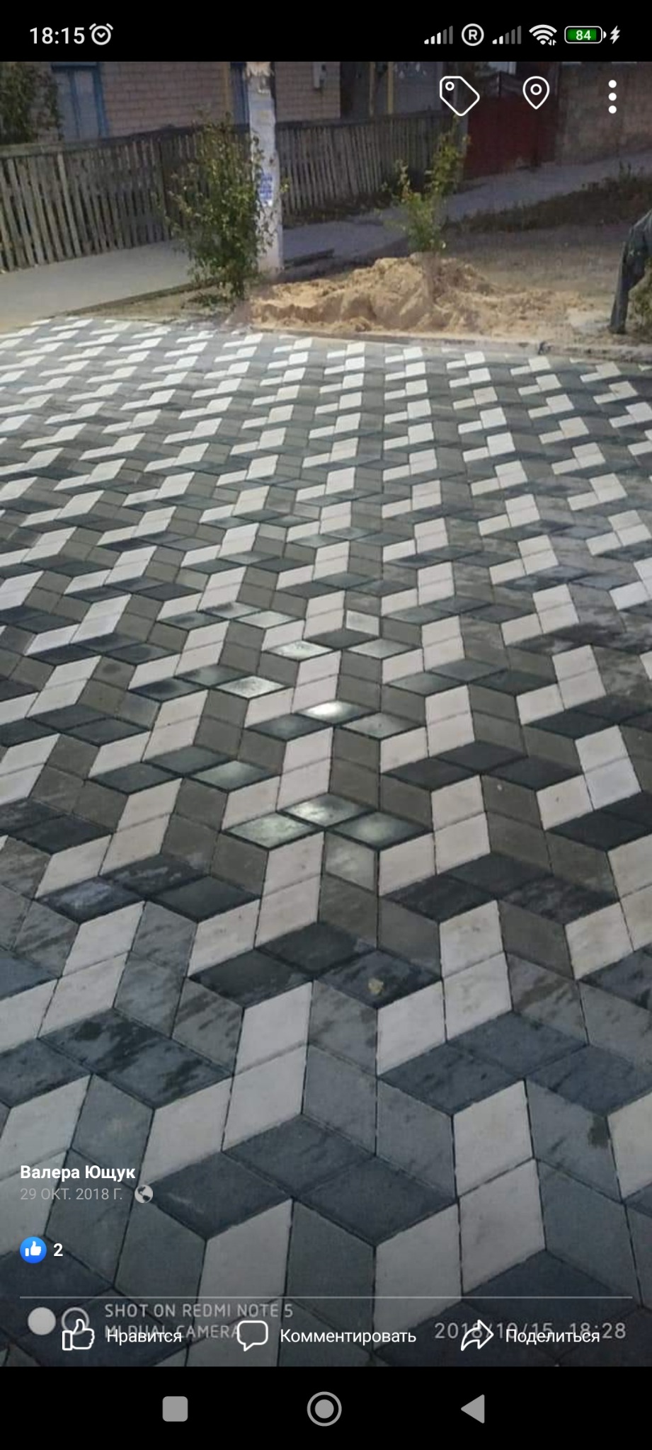 Ułożona kostka brukowa w geometryczny wzór 3D z szarych i białych elementów, widok z góry.