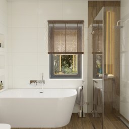 Pracownia Projektowa Zmyślone Wnętrza - Nowoczesna łazienka z wolnostojącą białą wanną, kabiną prysznicową ze szklanymi drzwiami i drewnianymi akcentami, widok na zieleń za oknem z drewnianymi żaluzjami.