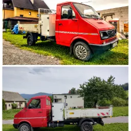 Czerwony samochód dostawczy z białą skrzynią ładunkową i charakterystycznym wzorem szachownicy, zaparkowany na trawie przed budynkiem w słoneczny dzień.