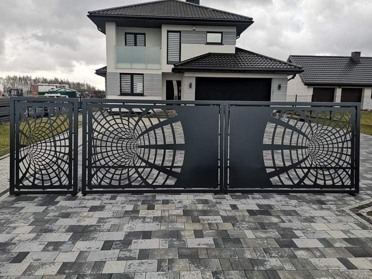 Nowoczesna brama wjazdowa z geometrycznym wzorem tunelu na tle domu z garażem i kostki brukowej.