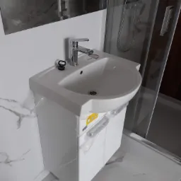 Biała umywalka z szafką, model Koło, z chromowaną baterią, zamontowana w łazience z białymi płytkami imitującymi marmur, obok kabina prysznicowa ze srebrnymi profilami, widoczne folie ochronne...