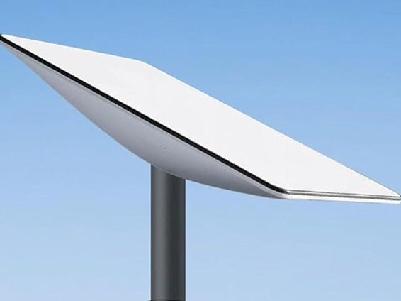 Biała antena satelitarna Starlink na szarym słupku, skierowana w lewo, na tle błękitnego nieba. Minimalistyczny design, czyste linie, nowoczesna technologia.