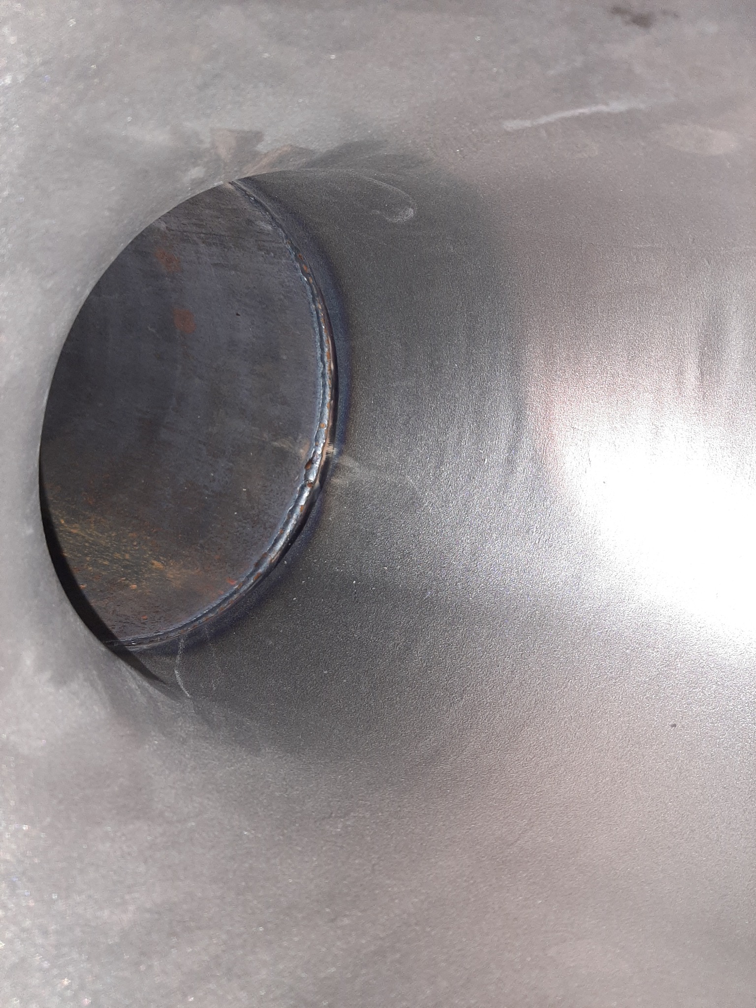 Wnętrze rury ze stali nierdzewnej z widocznym spoiną obwodową, wykonaną metodą TIG, z lekkimi przebarwieniami termicznymi.