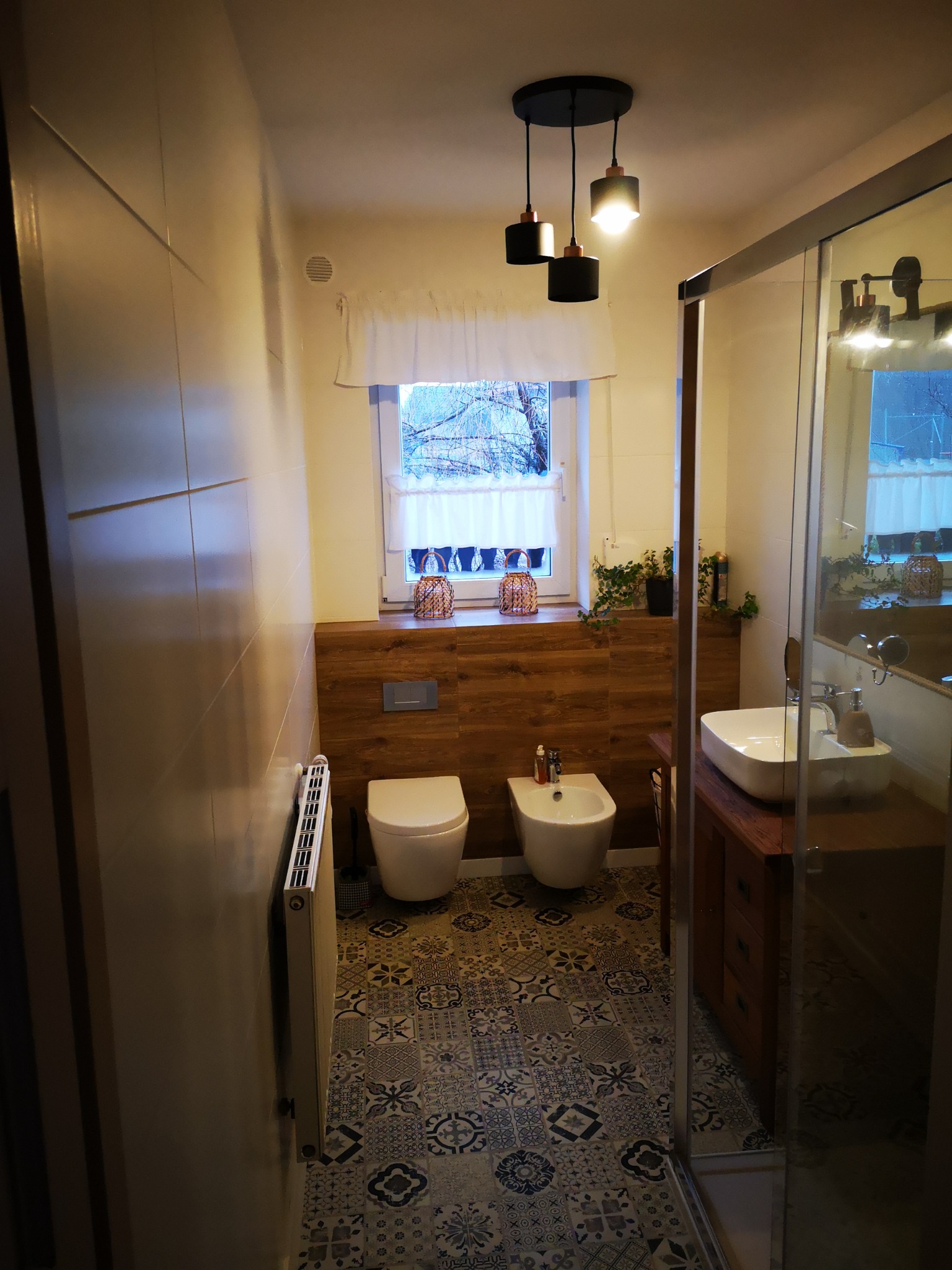 Nowoczesna łazienka z drewnianymi akcentami: drewniana boazeria, szafka pod umywalką z drewna, wiszące lampy w stylu industrialnym z miedzianymi detalami, dekoracyjna podłoga w stylu patchwork...