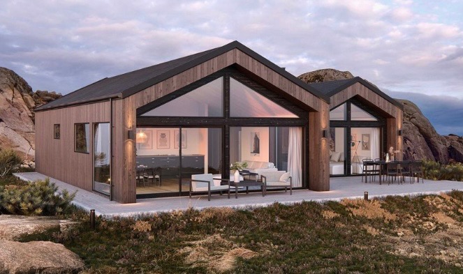 Nowoczesny, dwusegmentowy budynek z drewnianą elewacją i dużymi przeszkleniami, otoczony naturalnym krajobrazem z widocznymi skałami.