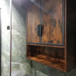 Rustykalna szafka wisząca z półką w łazience z marmurowymi płytkami. Czarny, podwójny uchwyt. Widoczny fragment kabiny prysznicowej.