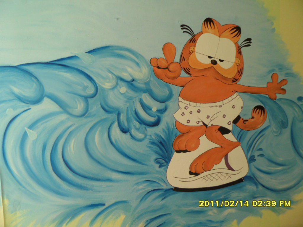 Ręcznie malowane malowidło ścienne przedstawiające Garfielda surfującego na fali w majtkach w kropki, wykonane w pokoju dziecięcym.