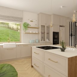 Projektowanie wnętrz Sylwia Rygielska - Jasna kuchnia z wyspą i widokiem na zieleń za oknem. Beżowe szafki, złote akcenty i drewniane wykończenia tworzą przytulną, nowoczesną przestrzeń. Uwagę przyciąga duża szyba okienna.