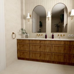 Projektowanie wnętrz Sylwia Rygielska - Nowoczesna łazienka z drewnianą szafką pod umywalką, dwoma lustrami w złotych ramach i beżowymi płytkami. Widoczne złote akcenty i minimalistyczne oświetlenie.