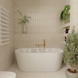 Projektowanie wnętrz Sylwia Rygielska - Beżowa łazienka z wanną wolnostojącą, złotą armaturą i roślinami. Minimalistyczny design z akcentami natury i ciepłym oświetleniem. Widok na ścianę z podłużnymi płytkami.