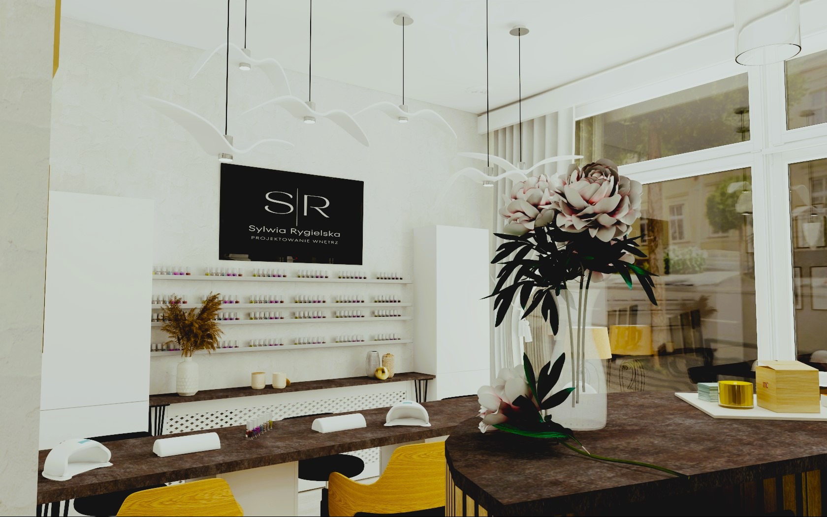 Wnętrze salonu kosmetycznego z białymi ścianami, półkami z lakierami, stanowiskami do manicure z lampami UV i dekoracyjnymi lampami sufitowymi w kształcie ptaków. Na pierwszym planie wazon z kwiatami.