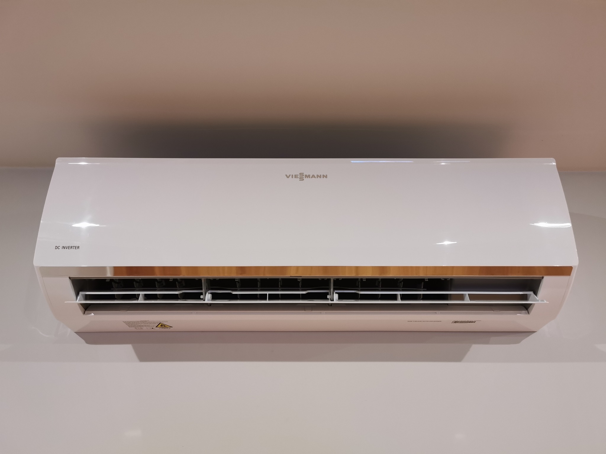 Biała jednostka wewnętrzna klimatyzacji Viessmann DC Inverter zamontowana na jasnej ścianie.