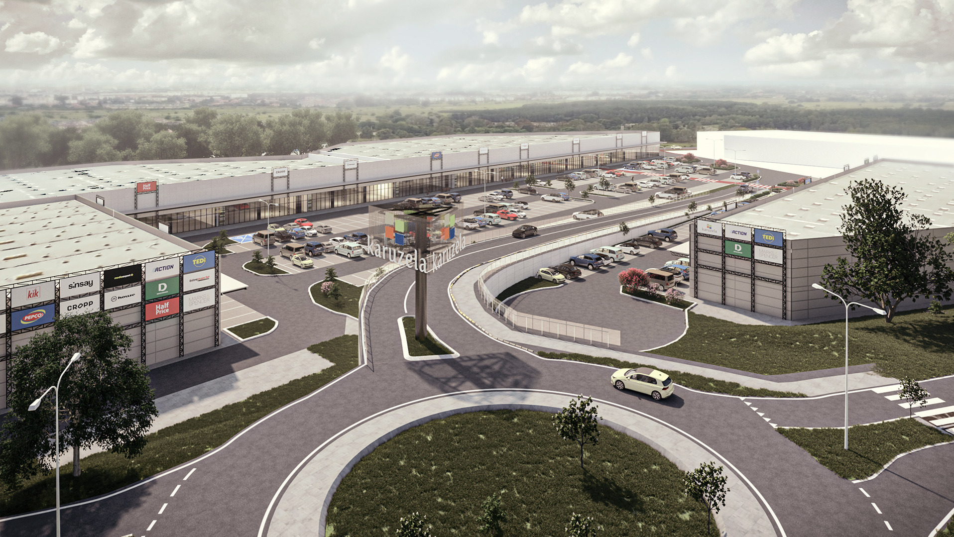 Wizualizacja 3D parku handlowego Karuzela w Jastrzębiu Zdroju, prezentująca budynki z parkingami, charakterystyczny pylon z nazwą oraz otoczenie z zielenią i drogami dojazdowymi.