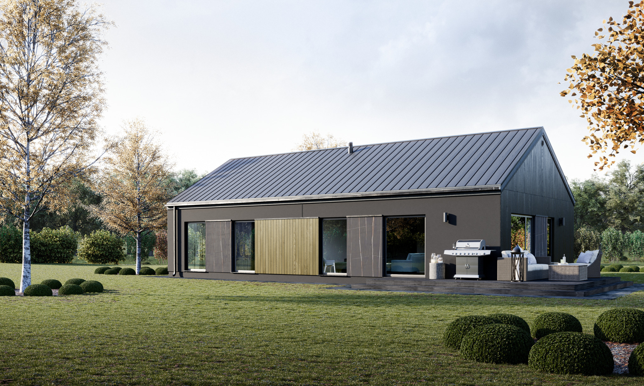Wizualizacja nowoczesnego, parterowego domu modułowego z ciemną elewacją, metalowym dachem i drewnianymi akcentami, otoczonego zielonym trawnikiem i drzewami z jesiennymi liśćmi; na tarasie grill...