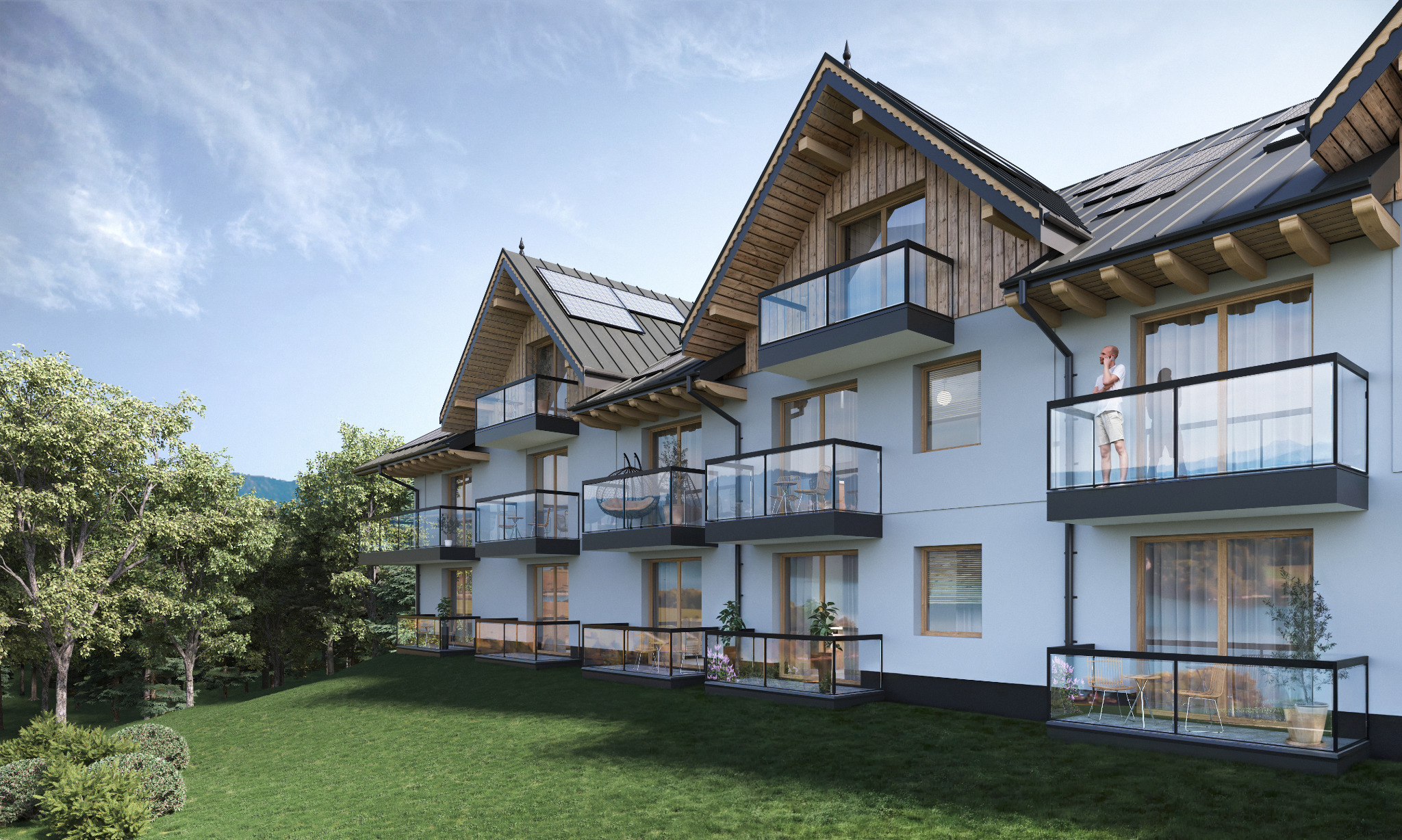 Wizualizacja budynku wielorodzinnego z balkonami w stylu góralskim, z panelami słonecznymi na dachu, otoczonego zielenią i częściowo widocznymi górami w tle.