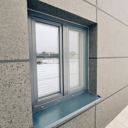 dekoroleta.pl - Szare okno z poziomymi przesłonami wewnętrznymi w elewacji z szarego betonu architektonicznego.