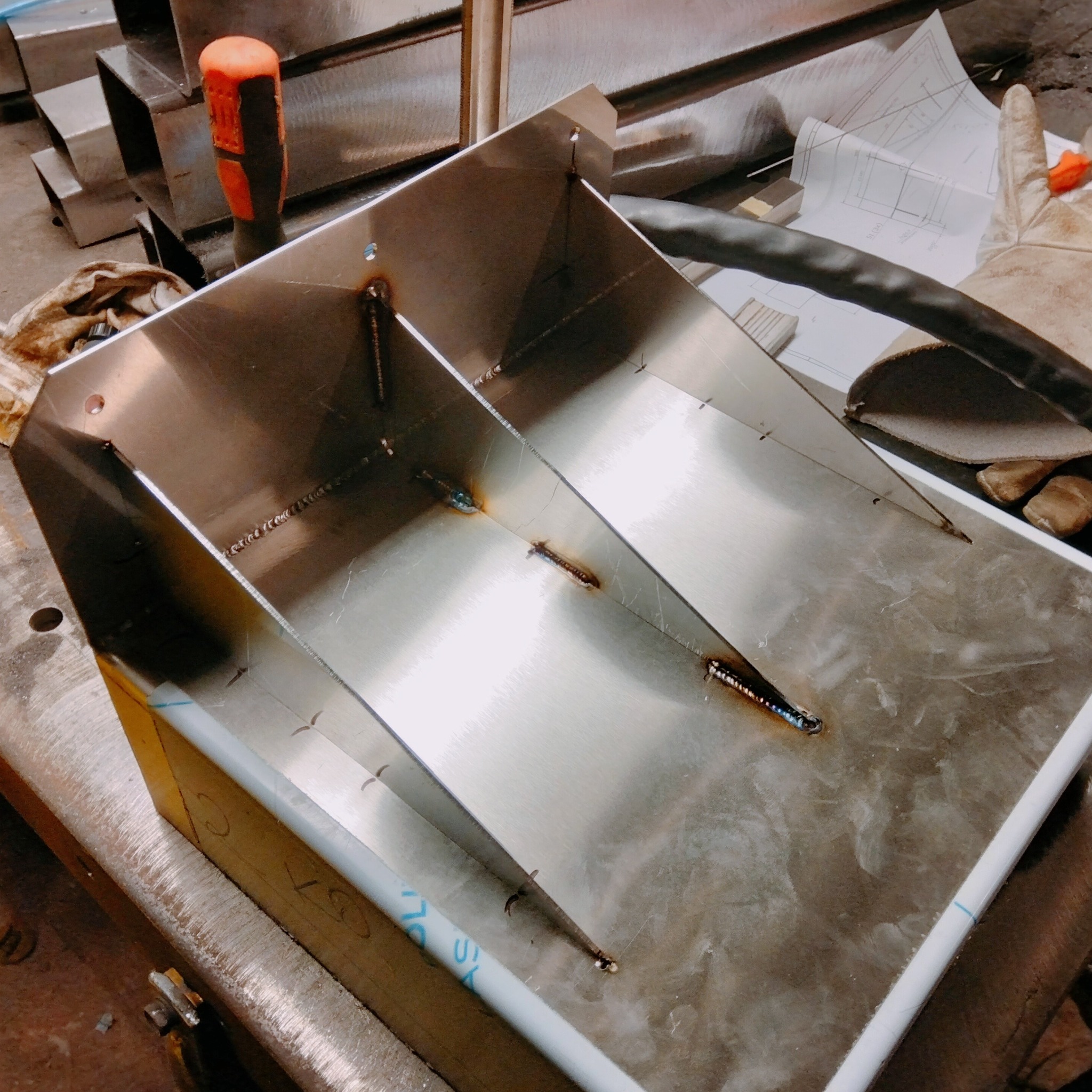 Spawanie konstrukcji ze stali nierdzewnej w Woli Zgłobieńskiej. Widoczne spawy, narzędzia i rysunek techniczny. Detal wykonany z precyzją.