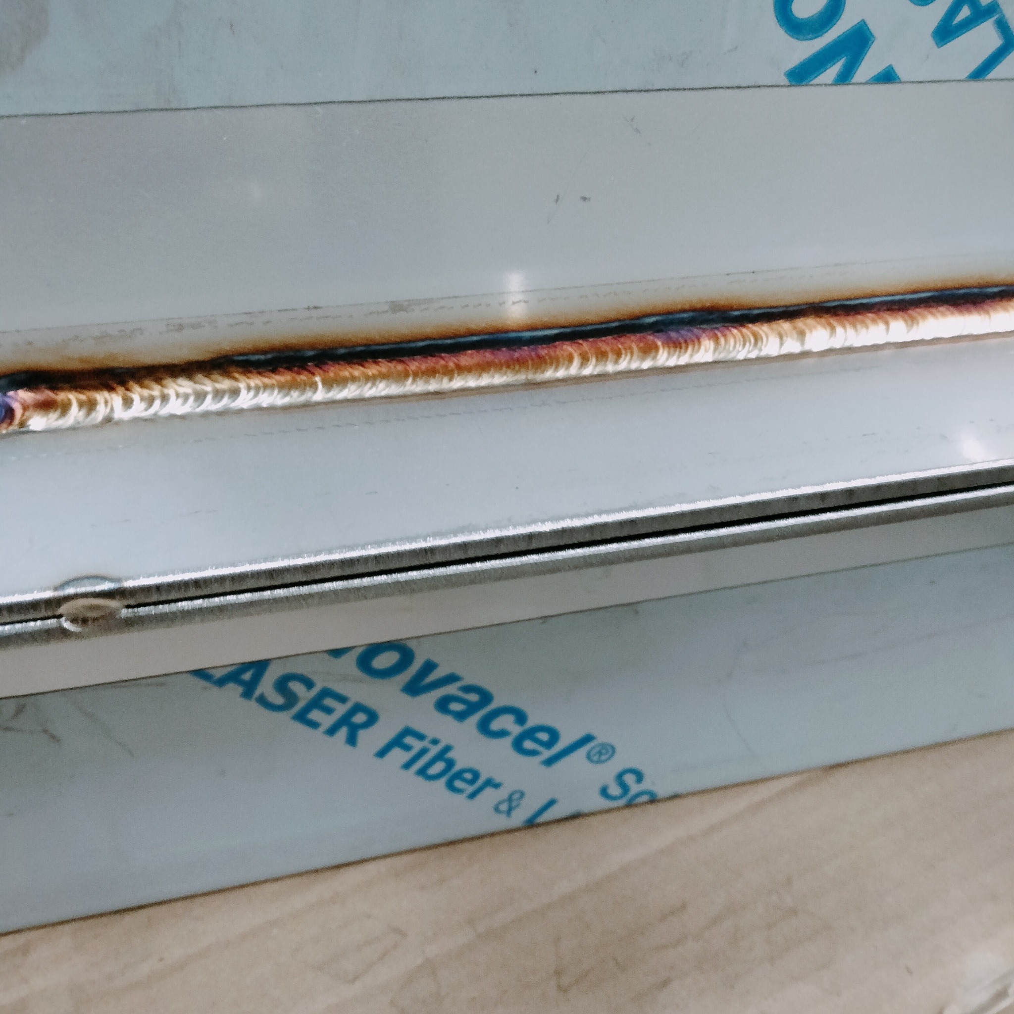 Szczegółowe zbliżenie na precyzyjny spaw na metalowej konstrukcji, ukazujący estetyczne połączenie i termiczne zabarwienie spoiny.