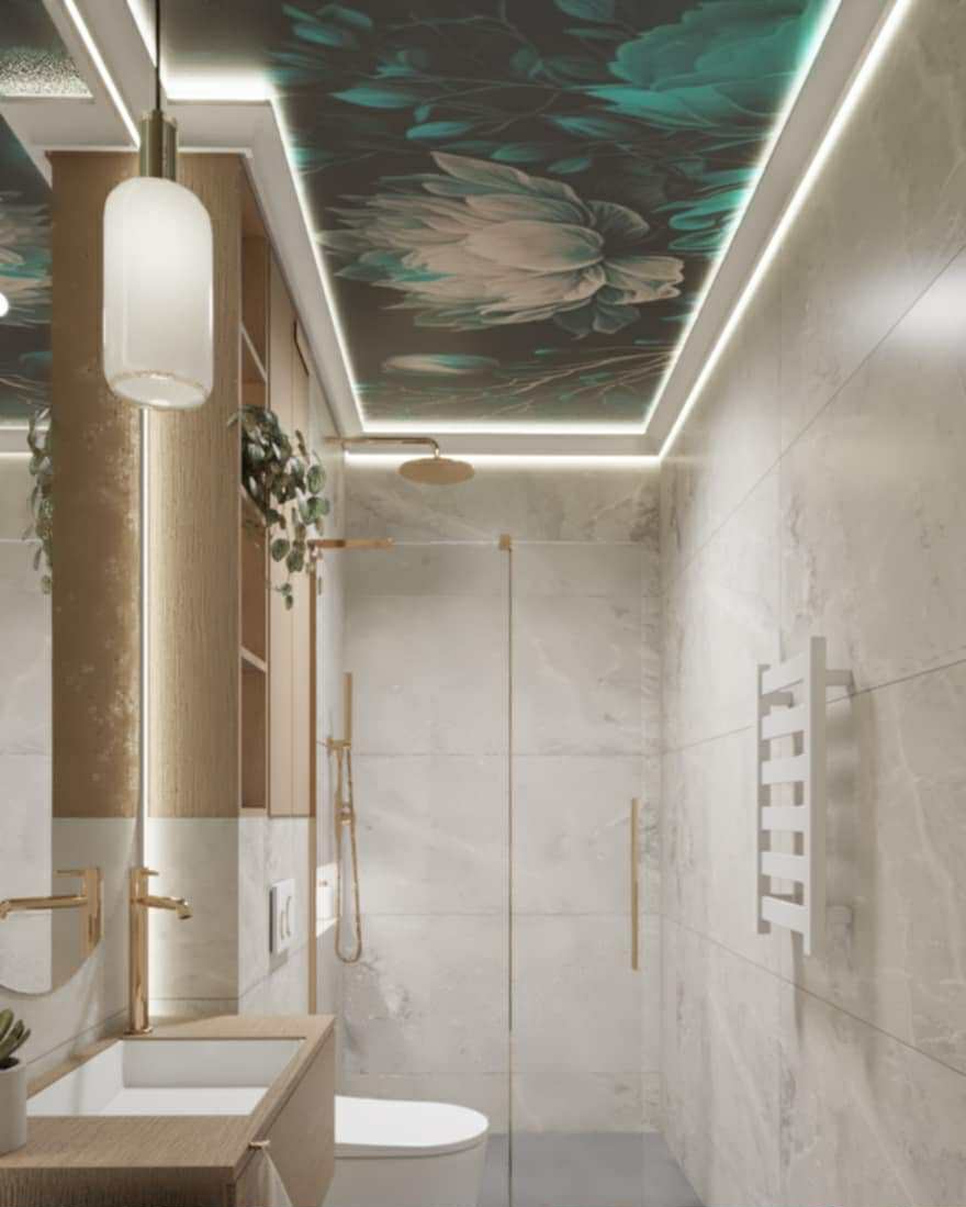 Elegancka łazienka z marmurowymi płytkami, złotą armaturą i sufitem z motywem kwiatowym podświetlonym LED, tworząca luksusowe i nowoczesne wnętrze.