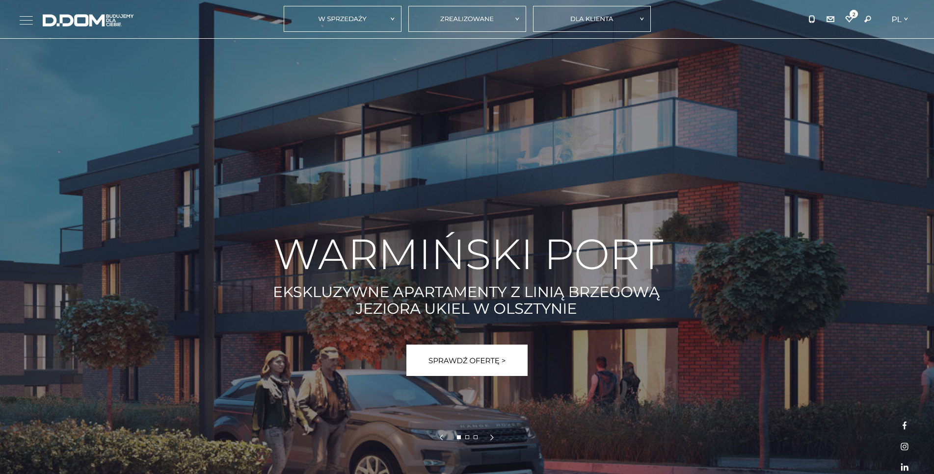 Wizualizacja apartamentowca Warminski Port w Olsztynie z linią brzegową jeziora Ukiel, prezentująca elewację z ciemnej cegły, szklane balustrady balkonów, z parą spacerującą obok zaparkowanego...