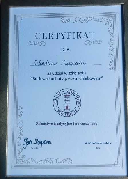 Oprawiony certyfikat dla Wiesława Suwały za udział w szkoleniu 'Budowa kuchni z piecem chlebowym', wydany przez Cech Zdunów Polskich, z widocznym logo cechu przedstawiającym wieżę.