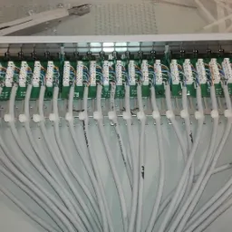 Panel krosowniczy z podłączonymi kablami sieciowymi, widoczne narzędzia instalacyjne