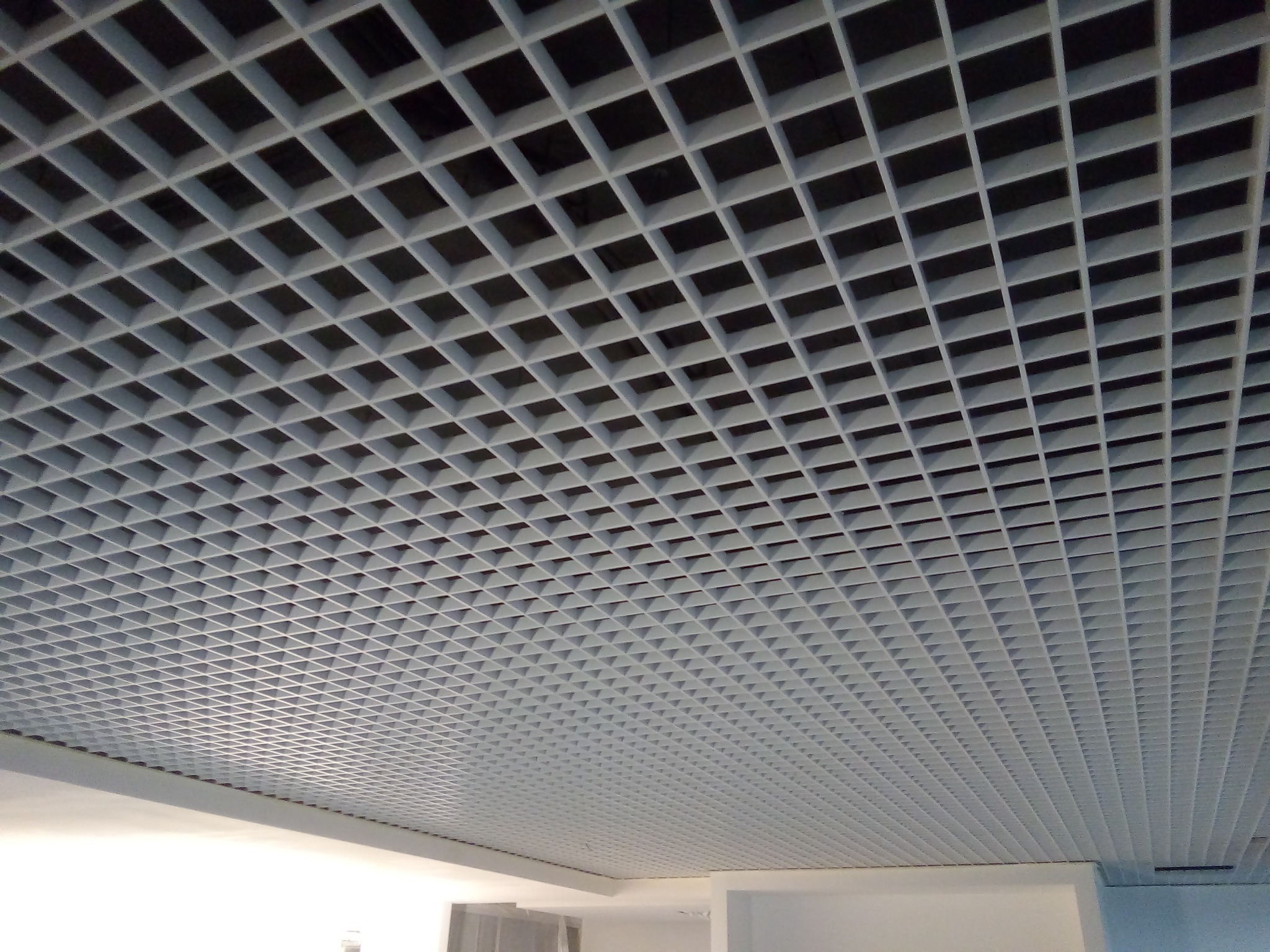 Sufit podwieszany z kratownicą w pomieszczeniu biurowym, widok z dołu pod kątem.