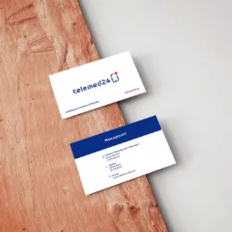 Dwie wizytówki firmy telemed24.pl leżące na drewnianej powierzchni z widoczną fakturą. Górna wizytówka prezentuje logo i hasło firmy, dolna zawiera dane kontaktowe.