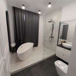 SAMBUD Oleksandr Subbotenko - Nowoczesna łazienka z wolnostojącą wanną, kabiną prysznicową typu walk-in i umywalką nablatową. Czarno-biała kolorystyka, marmurowe płytki i minimalistyczne oświetlenie.