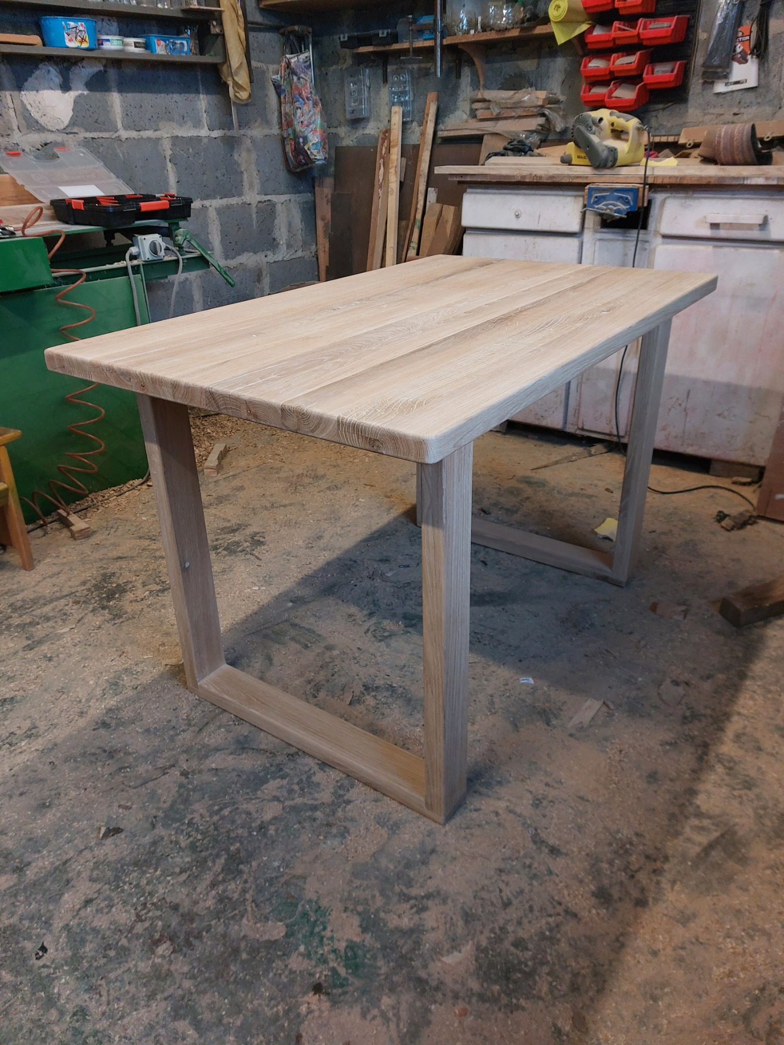 Surowy, drewniany stół z jasnego drewna w warsztacie w Tuszowie Narodowym, z widocznymi śladami obróbki i narzędziami w tle.