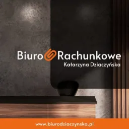 Logo Biura Rachunkowego Katarzyna Dziaczyńska z pomarańczowym symbolem spinacza, umieszczone na tle szarej ściany i drewnianego blatu z czarnym wazonem.