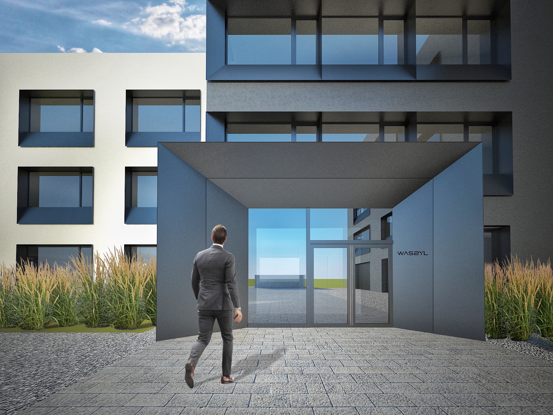 Mężczyzna w garniturze wchodzi do nowoczesnego budynku biurowego we Wrocławiu z szarą elewacją i szklanymi drzwiami, otoczonego ozdobnymi trawami i brukowanym chodnikiem.