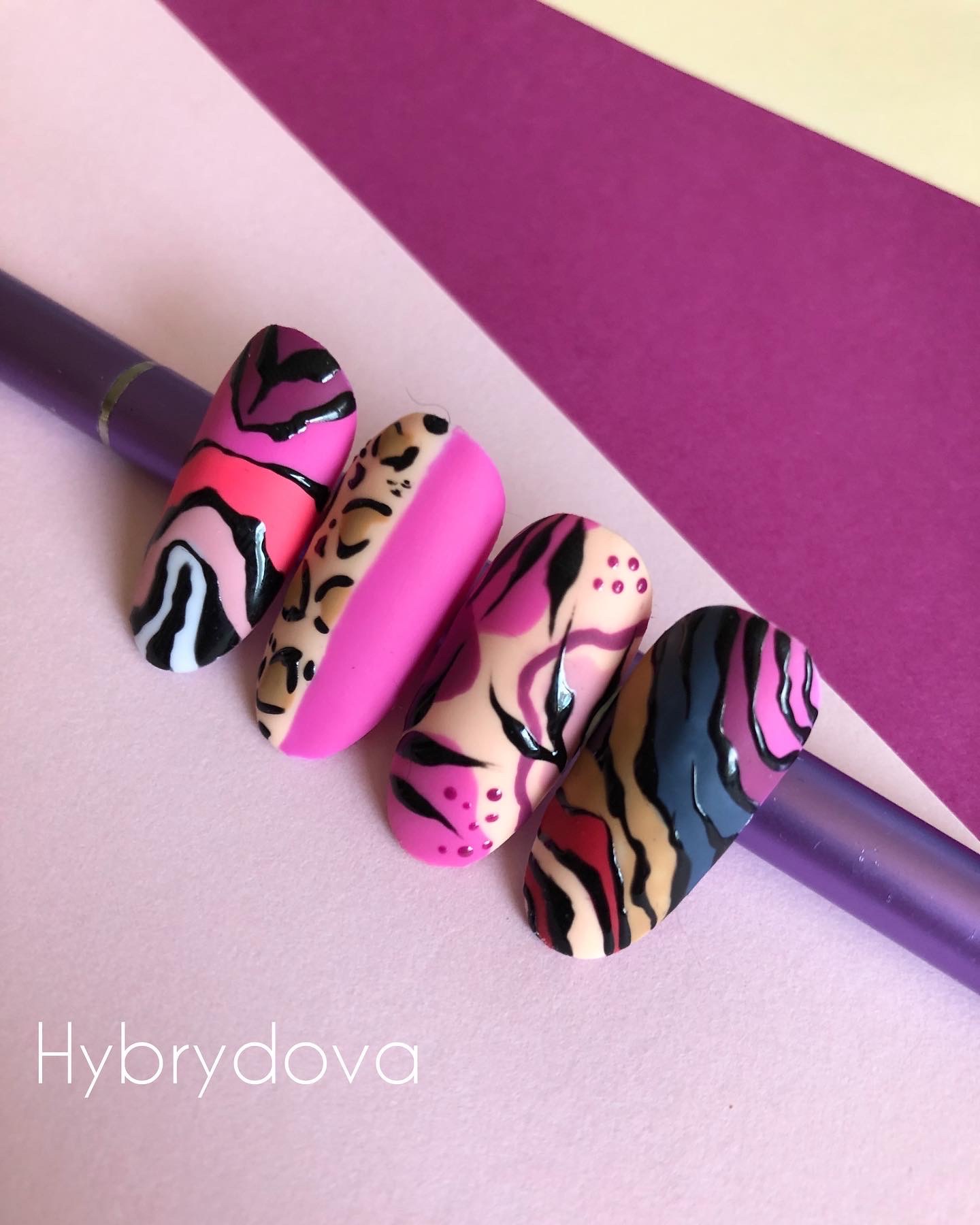 Cztery tipsy z różnorodnymi wzorami: abstrakcyjne paski w odcieniach różu i czerni, panterka z różowym akcentem, wzory przypominające marmur w kolorach różu i beżu z czarnymi akcentami,...