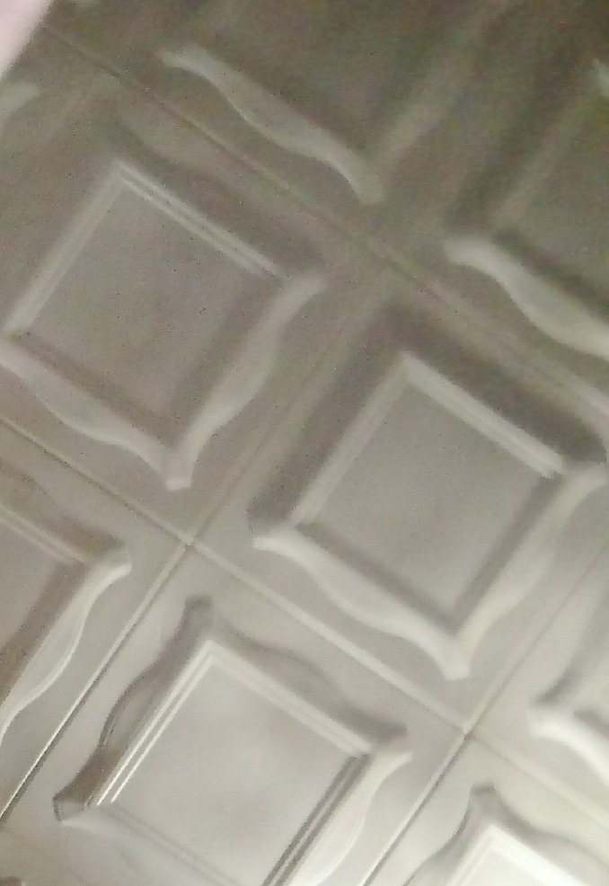 Dekoracyjne panele ścienne z efektem 3D, ułożone pod kątem, tworzące wzór kwadratów z ozdobnymi krawędziami.